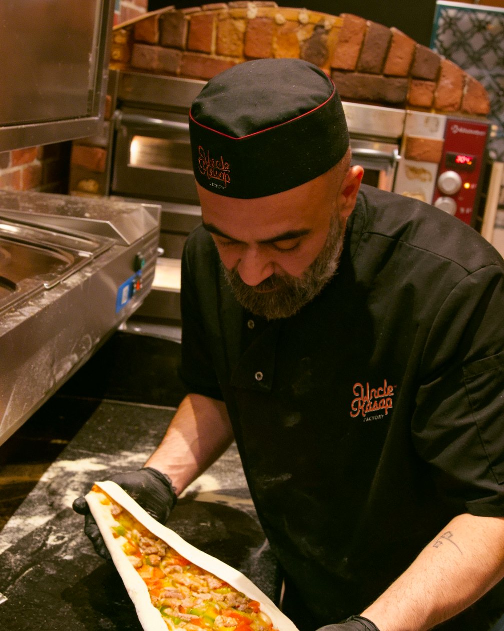 Le chef d'Uncle Kasap prépare une pide devant le four à pierre